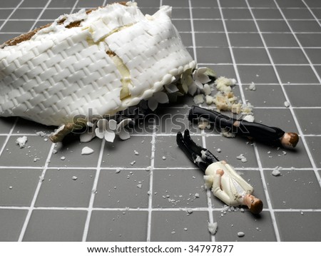 stock photo Two groom figurines lying at destroyed wedding cake on tiled 