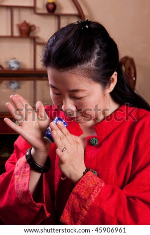 Attractive woman inside a traditional tea house, reading tea leaves