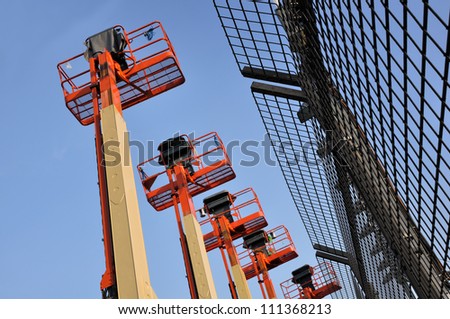 Close up of industrial boom lift basket against a blue sky.