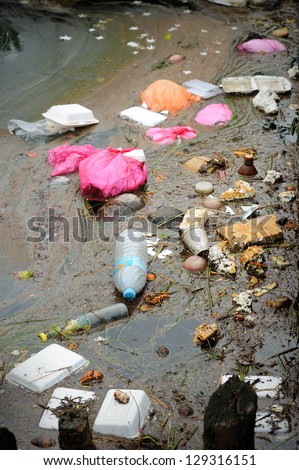 Close up of plastic and polystyrene fast food packaging in a river.