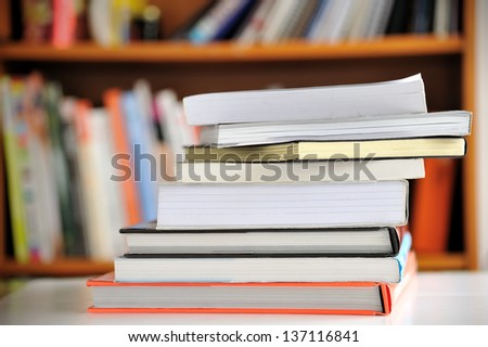 Stack of Education books on table in library, selective focus.