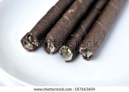Close up of chocolate vanilla rolled wafer, selective focus.