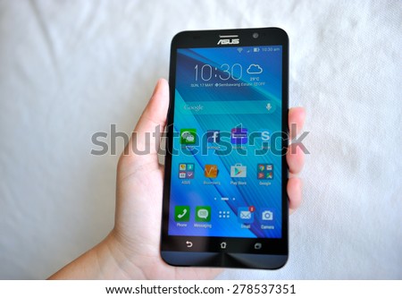 SEMBAWANG, SINGAPORE - MAY 17, 2015: Woman holding brand new Asus Zenfone 2. Social media are trending and both business as consumer are using it for information sharing and networking.
