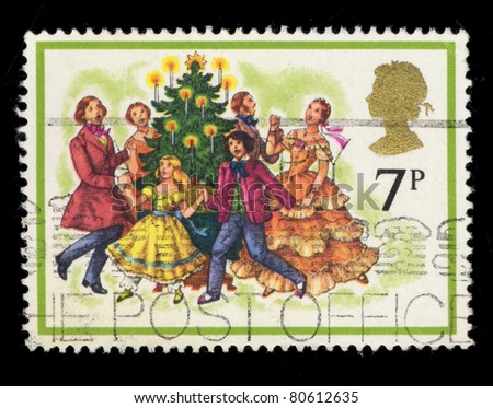UNITED KINGDOM - CIRCA 1978: A stamp printed in United Kingdom shows Carol Singers around a Christmas Tree, circa 1978