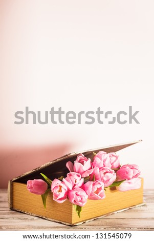 Shabby chic decoration - pink tulips in vintage book with copy space
