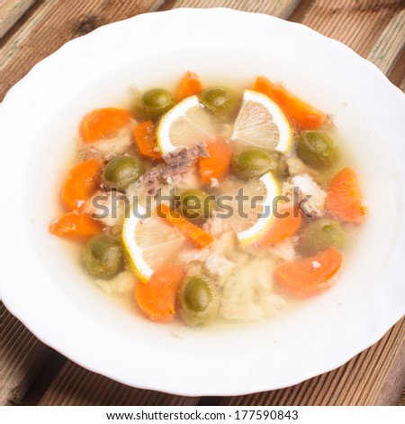 Sturgeon with lemon and carrot slices and green olives in aspic
