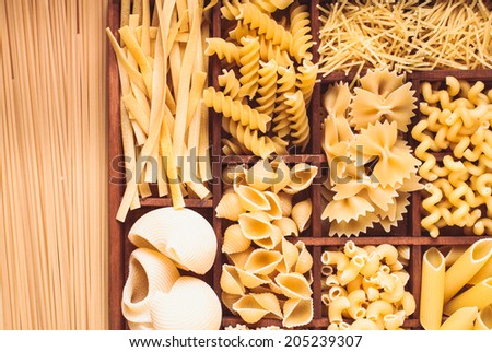 Various pasta  types in the wooden box on the table
