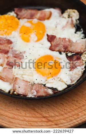 Fried bacon and eggs on the pan - rusty breakfast