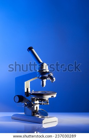 Microscope on the table in laboratory with blue light