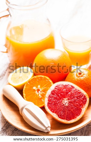 The preparation for citrus juice for breakfast. Wooden  citrus reamer with fruits.