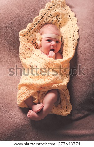 Newborn baby girl on the crochet blanket