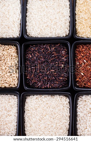 Various types of rice in black bowls close up
