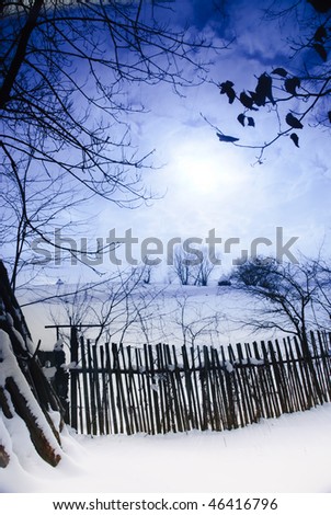 Rural winter mountain landscape with sundown and road, trees, fence