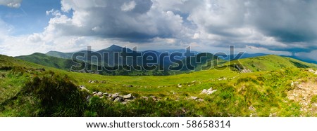 Beautiful blue sky and grass high up in Carpathian mountains, storm is coming. Goverla behind