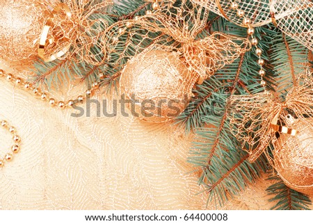 Gold Christmas ribbon, balls and beads on green pine branch. Old film stylized.