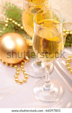 two glasses of champagne and gold christmas decorations