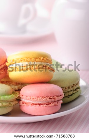 Pink, yellow, green macaroones on white plate close up