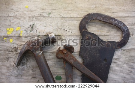 Ancient tools: saw, pincers, hammer on a old wooden background