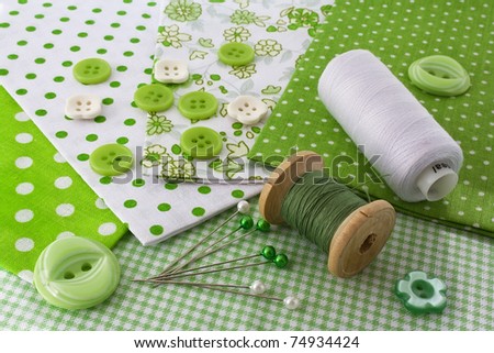 Accessories for sewing: threads, fabric, buttons in green-white color