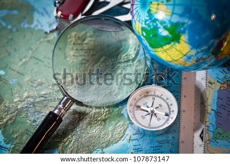 Image of compass,magnifier grass on world map, concept of world discovery.