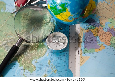 Image of compass,magnifier grass on world map, concept of world discovery.