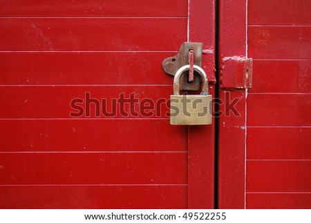 Metal padlock on a red door