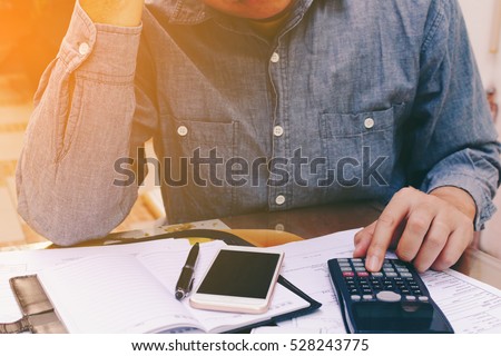 Man counting using calculator and stress in problem with expenses.
