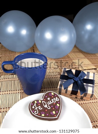 Sweet cookie with spanish text love, gift box, cup of coffee and balloons