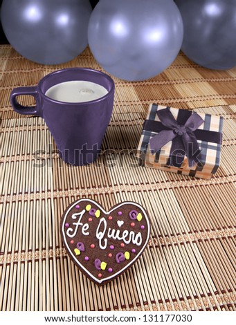 Sweet chocolate heart cookie with cup of coffee, gift box and balloons