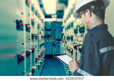 Double exposure of  Engineer or Technician man working with tablet in switch gear electrical room of oil and gas platform or plant industrial for monitor process, business and industry concept