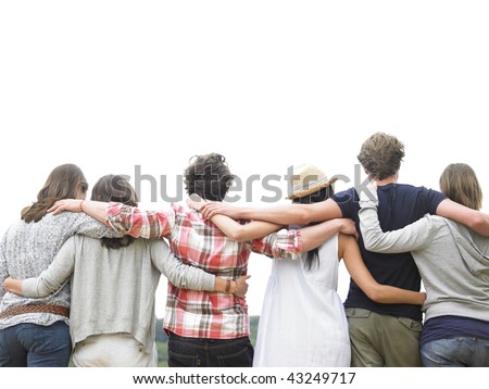 Rear view of group of friends hugging. Horizontal.