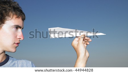 Young man getting ready to throw a paper airplane. Horizontal shot.