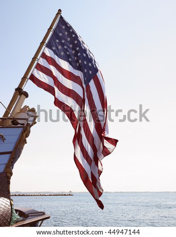 American flag flying off front of boat. Vertical shot.