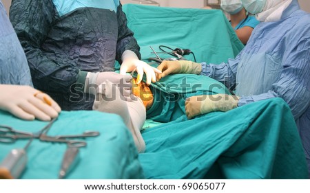 surgeons holding medical instruments in hands and looking at patient