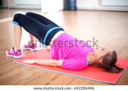 Happy woman doing pelvic muscle exercise on mat