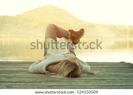 Woman relaxing on the pier and reading book