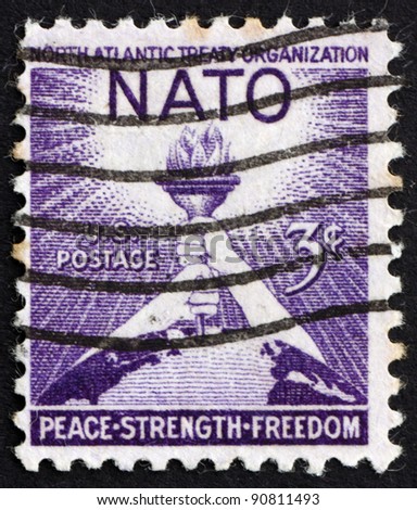 UNITED STATES OF AMERICA - CIRCA 1952: a stamp printed in the United States of America shows Torch of Liberty and Globe, 3rd anniversary of the signing of the North Atlantic Treaty, circa 1952