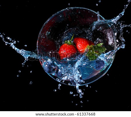 Fruit splashing into a glass of blue liquid. Concept - make a splash
