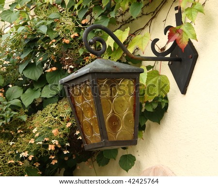 Antique lamp at overgrown wall