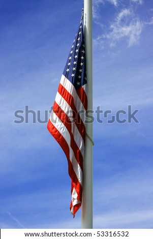 American flag takes a rest as the wind calms down against the dark blue summer sky in the background.