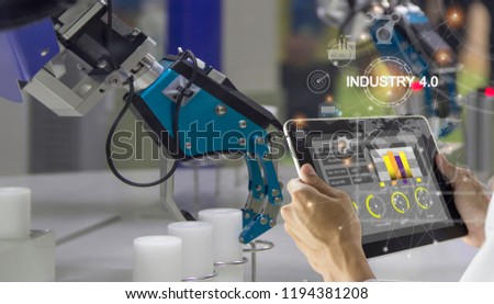 Industry 4.0 Robot concept .Engineers use laptop computers for machine maintenance, automation tools, robot arm at the factory.