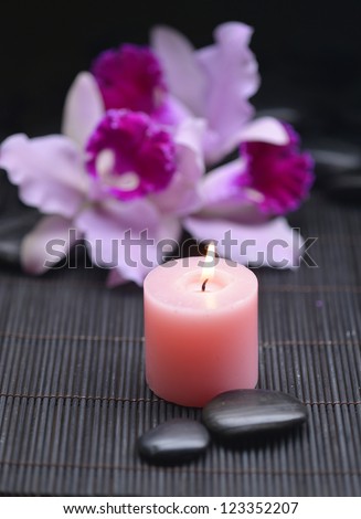 Spa setting-beautiful orchid with candle and zen stones on mat