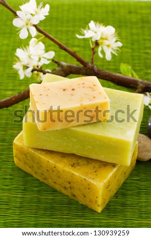 branch with cherry flowers and handmade soap on mat