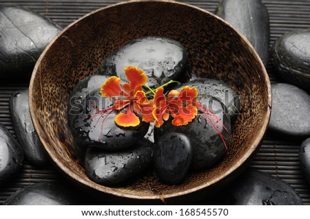 Beautiful orchid and zen Stones in bowl on bamboo mat