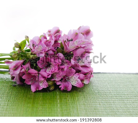 Lying down bouquet of orchid and wet Stones on green straw mat