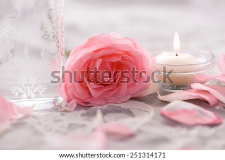 rose petals and rose with candle on lace