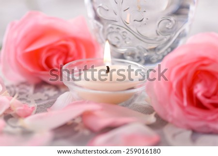 rose petals and rose with candle in bowl  on lace