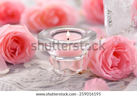 rose petals and rose with candle on lace