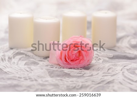 One rose with candle on lace