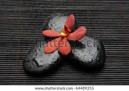 Beautiful orchid and zen Stones on bamboo stick straw mat